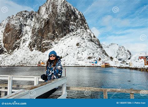 Tourist Woman Standing Near Traditional Fishing House Rorbu In Reine