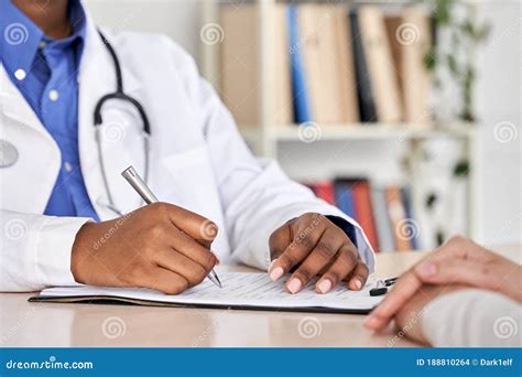 African Black Doctor Consult Woman Patient Filling Medical Form At