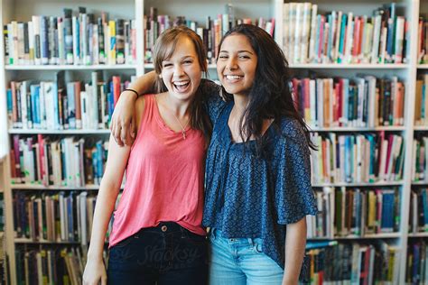 Two High School Teensage Friends Laughing Together In Library By