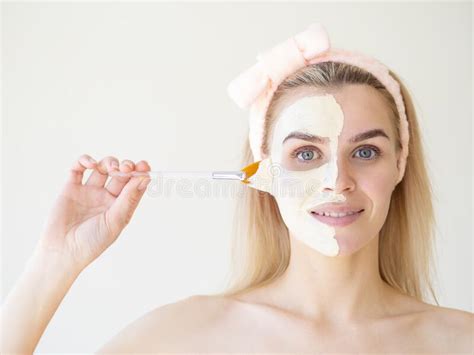 beauty treatments portrait of spa caucasian girl applying facial mask on a half face with