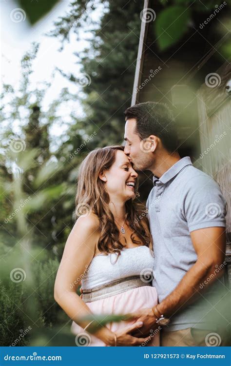 Husband Is Kissing His Pregnant Wife On Her Forehead Stock Image