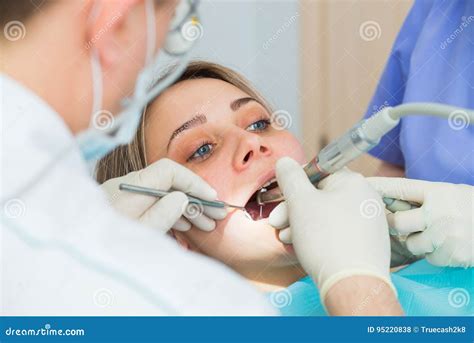 Young Woman Getting Dental Treatment Closeup Hands Of Dentist And