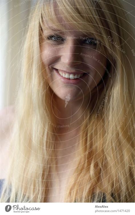 portrait einer jungen blonden sommersprossigen frau die in die kamera lächelt ein