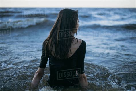Caucasian Woman Wearing Dress Wading In Ocean Stock Photo Dissolve