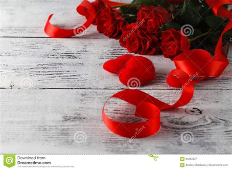Accoppiamenti dei pattini femminili rossi e mazzo di rose rosse. Mazzo Di Rose Rosse Sulla Tavola Immagine Stock - Immagine di scheda, retro: 84283537