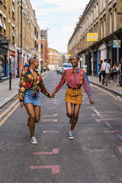 Stylish And Happy Black Women Walking Hand By Hand By Stocksy