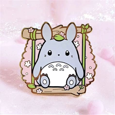 A Pin With An Image Of A Totoro Sitting In Front Of A Pink Background