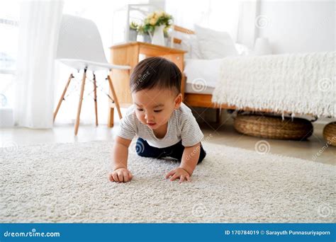 Baby Boy Crawling On The Floor In Living Room Indoors Toddler Asian