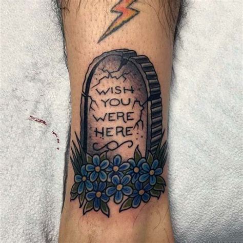 cartoon like little colored tombstone with lettering and flowers tattoo on ankle tattooimages