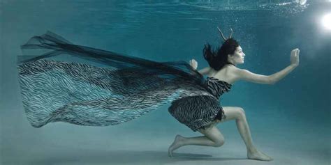 A Woman In A Dress Is Under Water