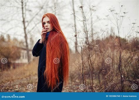 Woman With Long Red Hair Walks In Autumn On The Street Mysterious Dreamy Look And The Image Of