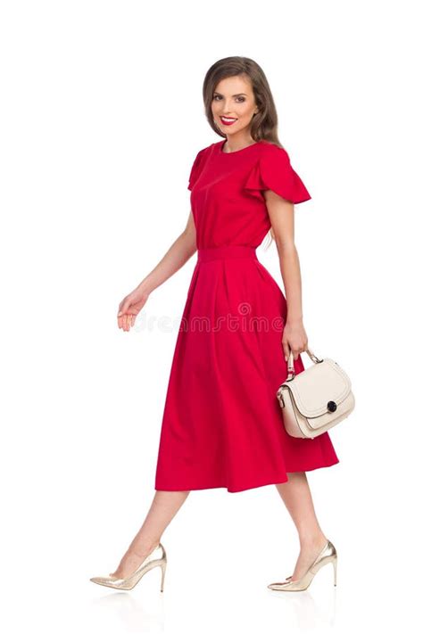 Walking Beautiful Woman In Red Dress Gold High Heels And Beige Purse