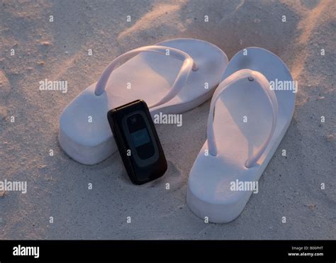 Pair Of Thongs And Cell Phone On The Beach Stock Photo Alamy
