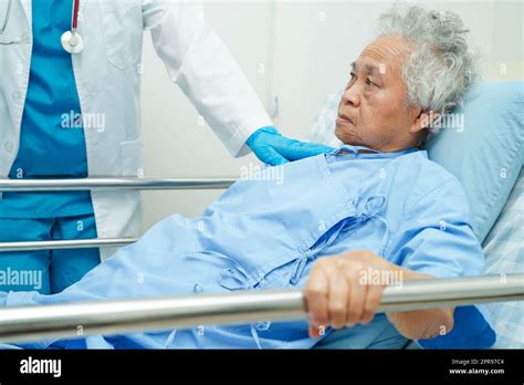 Asian Elder Senior Woman Patient Holding Bed Rail While Lie Down With