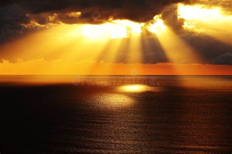 Golden Sunlight Through Dark Clouds Over Ocean Stock Photo Image