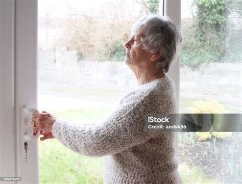 Nosey Neighbour Senior Woman Looking Through Window Stock Photo