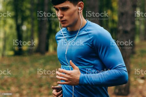 Closeup Portrait Of Young Athlete Man Running Outdoor In The Forest