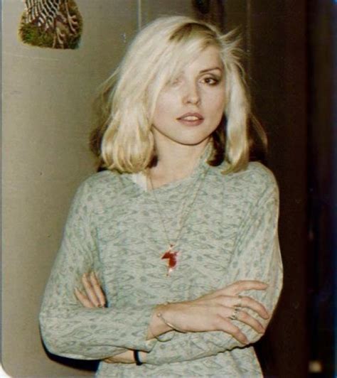 A Woman With Her Arms Crossed Standing In Front Of A Refrigerator