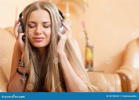 Young Attractive Girl Enjoying Music Through Headphones Lying O Stock