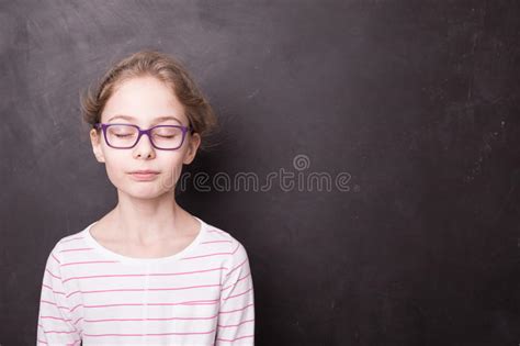 School Child Girl With Eyes Closed At The Blackboard Stock Photo