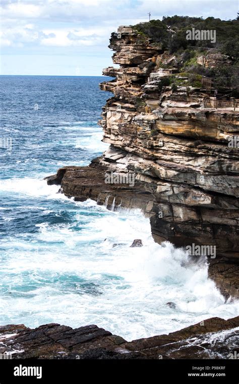 Ocean Waves Crashing Onto Jagged Rock Cliff Face Stock Photo Alamy
