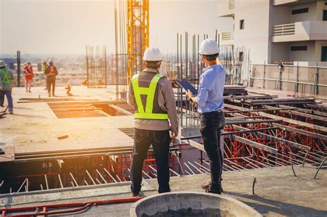 Structural Engineer And Foreman Worker With Touch Pad Discuss Plan