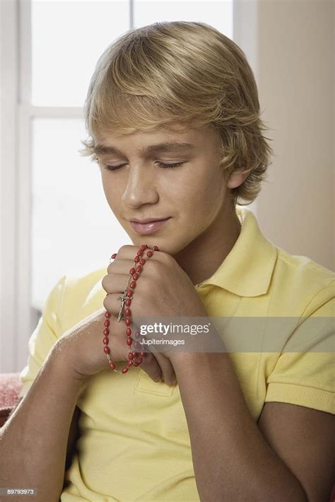 Boy Praying With Prayer Beads Indoors High Res Stock Photo Getty Images
