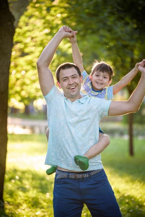 Father And Son Hugging And Playing Together In Green Nature On Warm