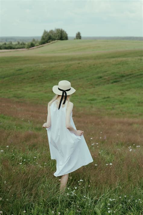 Woman In White Dress Walking On Green Grass Field · Free Stock Photo