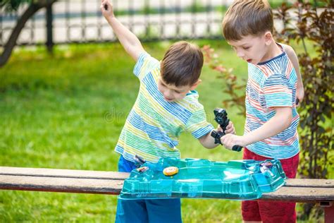 Two Boys Playing With A Top Spinning Top Kid Toy Popular Child Game