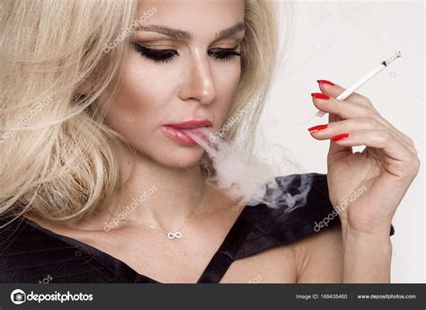 Sexy Blonde Woman Sensual Femme Fatale Sitting In Black Erotic Underwear And Smoking A Cigarette