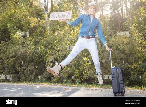 Active Funny Positive Blond Woman Hitchhiker Glad Of Car Traffic Jumping In Air Hold Blank