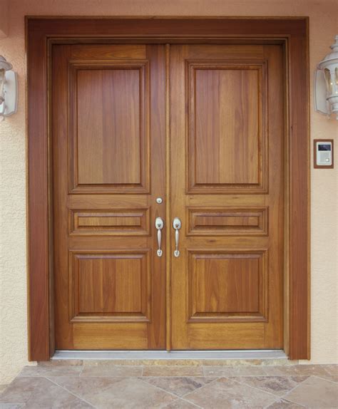 Two Wooden Doors Are Shown In Front Of A House