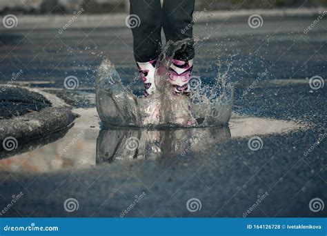 Girl Jumping Into Puddle Water Splash On Road Royalty Free Stock Image