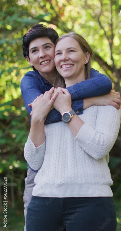 vertical video of happy caucasian lesbian couple embracing in garden stock ビデオ adobe stock