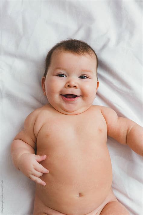 Chubby Infant Baby Nude On Bed Sheet Del Colaborador De Stocksy