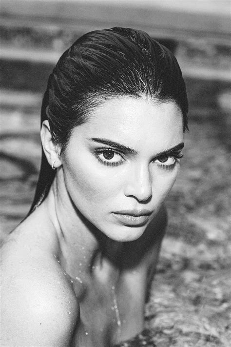 a black and white photo of a woman in the water looking at the camera with her eyes closed
