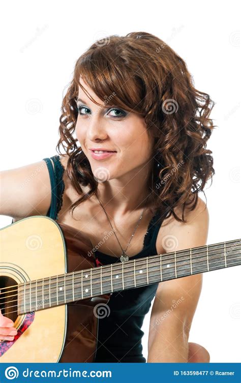 Beautiful Young Brunette Smiles As She Plays The Guitar Stock Image