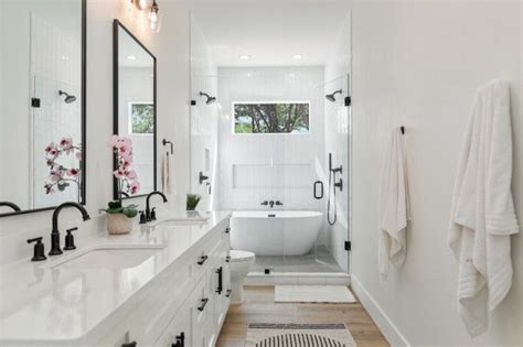 A Bathroom With White Fixtures And Black Accents