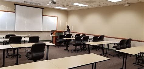 Empty Classroom With Tables Chairs Podiums Projector And Screen View