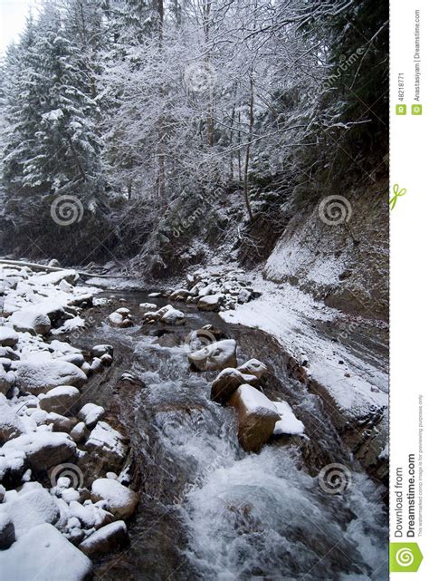 Waterfall In The Mountain Winter Forest With Snow Covered Trees And