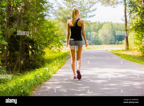 Young Woman Walks Alone On A Road Outdoor Stock Photo Alamy