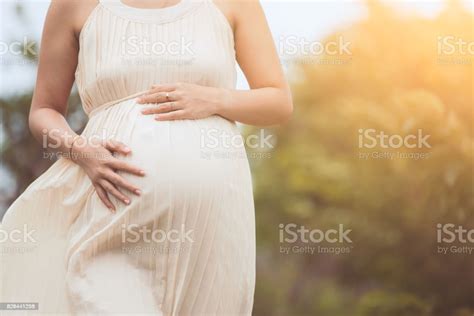 Pregnant Woman Touching Her Big Belly And Walking In The Park Stock