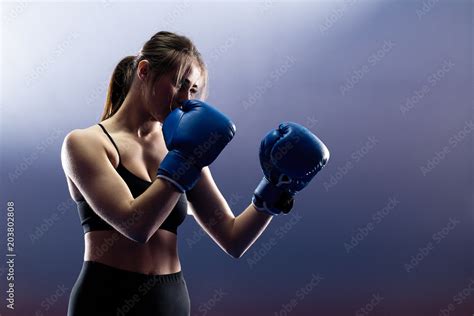woman with black boxing wraps and boxing gloves on hands boxing in ring active girl fight stock