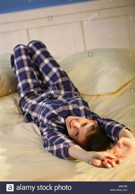 Woman Lying Down On Bed And Stretching Stock Photo Royalty Free Image Alamy