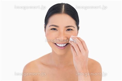 Cheerful Beautiful Model Removing Her Make Up On White Backgroundの写真素材
