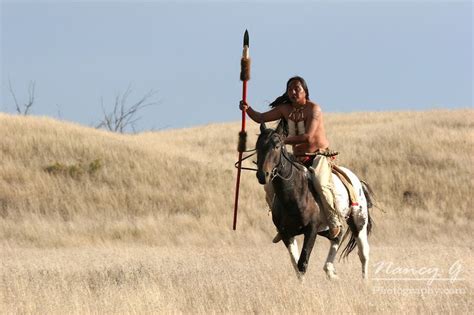 A Native American Lakota Indian Riding Horseback In The Prairie Of