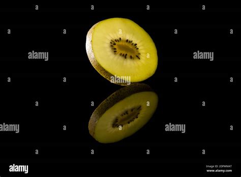 Slice Of Yellow Kiwi Fruit Against Black Background Stock Photo Alamy