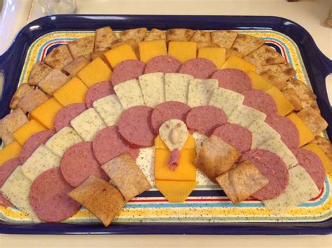 A Platter With Meats Cheese And Crackers Arranged In The Shape Of A Turkey