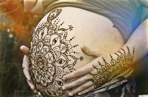A Pregnant Womans Belly Is Decorated With Hendix And Lace While Her